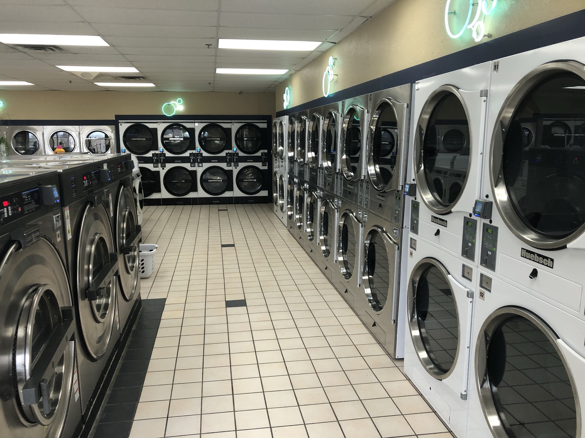 Aisle of washers and stacked dryers at Sun Laundry West Allis